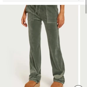 Gröna juicy couture byxor - Mysiga gröna mjukisbyxor med raka ben och dragsko i midjan. Byxorna har stora fickor framtill och är tillverkade i ett mjukt, sammetsliknande material. Perfekta för en avslappnad stil.