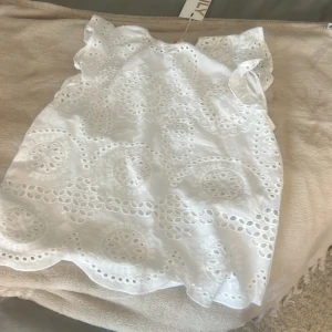 Vit broderad blus med volangärm - Superfin vit blus från only med broderade detaljer och hålmönster framtill. Blusen har volangärmar och en lätt vågig nederkant som ger en söt och somrig vibe. Perfekt till jeans eller kjol för en fräsch look. Pris kan diskuteras 