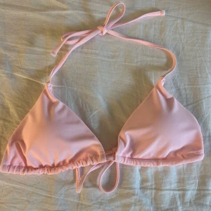 Ljusrosa bikiniöverdel  - Ljusrosa trekantsbikini med knyt i nacken och ryggen. Storlek xs. Skulle säga att kupan är som en A eller B. 