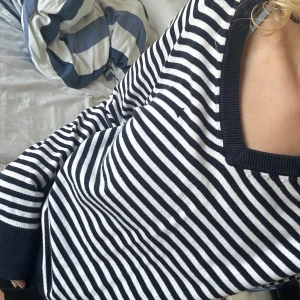 Randig stickad tröja  - Snygg stickad tröja med marinblå och vita ränder. Tröjan har lång ärm, ribbade muddar och en bred ribbad kant vid halsen. Perfekt för dig som gillar klassisk stil med en modern twist. Nypris cirka 700.