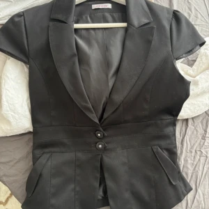 Svart väst topp - Säljer denna så fina väst toppen i ett så snyggt material från orsay. Passformen är så fin på. I princip ny skick