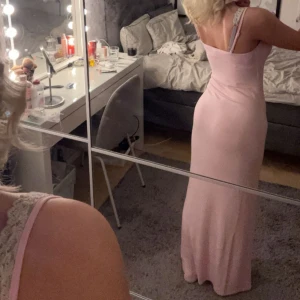 maxi slip dress från gina tricot  - Säljer en superfin ljusrosa långklänning med smala axelband och figurnära passform från gina tricot, soft touch. Klänningen har en enkel och stilren design som ger en snygg siluett. Perfekt för dig som gillar en feminin och clean look. storlek XS