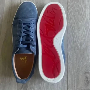 Blå mocka sneakers från Louboutin med röd sula - Snygga blå sneakers i mocka från Christian Louboutin med klassisk röd sula och vita kanter. Skorna har rund tå, platt sula och snörning. Insidan är i ljusbrunt skinn för extra komfort. Perfekta för dig som vill sticka ut med exklusiv stil. 10/10