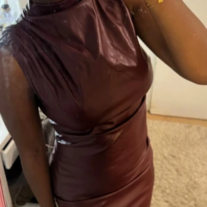 Vinröd lång klänning i skinn - Säljer en vinröd långklänning i skinn. Helt oanvänd! 