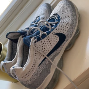 Nike Vapormax Flyknit - Nike Vapormax Flyknit sneakers i blått och vitt.  Använda 2-3 gånger och är så gott som nya!Perfekta för dig som gillar sportig och modern stil.
