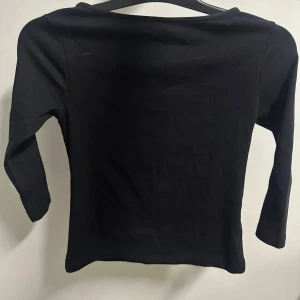trekvartärmad tröja  - En stilren svart långärmad topp i mjuk bomull. Enkel och clean design med rak halsringning och smal passform. Perfekt att matcha med jeans eller kjol för en snygg och avslappnad look. aldrig använd, råka dra av lappen så kunde inte lämna tillbaka