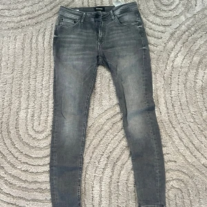 Grå skinny jeans Jack & Jones - Snygga grå skinny jeans från Jack & Jones, modell Spray On Tom. 