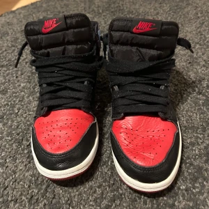 Jordan 1 unc to chi  - Ikoniska Jordan 1 Mid “UNC to CHI” – en unik och eftertraktad design som hyllar både University of North Carolina och Chicago Bulls. Med sin kombination av ljusblått och rödsvart läder, ger dessa sneakers en stilren och sportig look. Perfekta för sneakerheads eller för den som vill ge sin skogarderob en uppgradering.