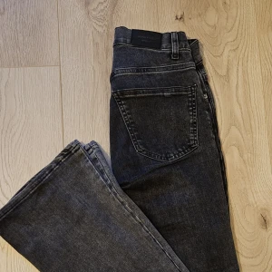 Gråa jeans från Gina Tricot - Snygga grå bootcut jeans från Gina Tricot med normal passform. Storlek 32 och är lågmidjade. 