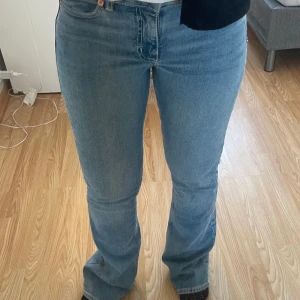 Ljusblå bootcut jeans - Säljer ett par ljusblå jeans med bootcut-modell. Jeansen har klassisk femficksdesign, normal passform och är tillverkade i mjukt denimtyg. Snyggt utsvängda ben och midja som sitter bekvämt. Perfekta till sneakers eller boots.