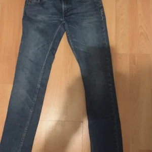 Tiger of Sweden blå jeans 26/32 - Snygga blå jeans från Tiger of Sweden i modellen Swanny. Klassisk femficksdesign, raka ben och normal passform. Jeansen har en mörkblå tvätt och är tillverkade i slitstarkt denim. Perfekta för dig som gillar stilrena och tidlösa jeans.