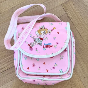 rosa coquette fairy väska 🧚‍♀️ - prinzessin Lillifee axelremsväska i ljusrosa färg med blommor, hjärtan och gulligt broderi. lite mindre fläckar på några ställen som man inte tänker så mycket på. Några smarta fack! 💕💕