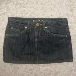 Mörk jeanskjol från Diverse Sys - Snygg mörkblå jeanskjol från Diverse Sys i klassisk femficksmodell. Kjolen är kort och har tydliga kontrastsömmar, bälteshällor och knappstängning framtill. Perfekt för dig som gillar en enkel men cool denimlook. Köp via Swish + frakt (ej köp nu) eller direkt via vinted @moa.06 (pga plicks nya avgifterk) 🩷