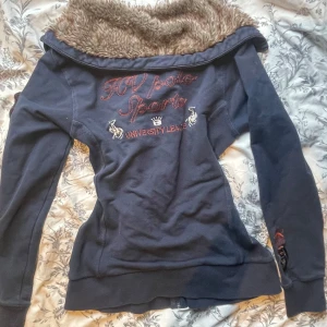 Marinblå zip up jacka med fuskpäls från HV Polo - Marinblå zip up jacka från HV Polo med dragkedja, broderade detaljer och stor krage fodrad med päls. Storlek M. Små defekter