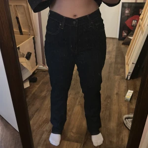 Levi's 724 High Rise Straight jeans - Mörkblå Levi's 724 High Rise Straight jeans med klassisk femficksdesign och raka ben. Hög midja och snygga kontrastsömmar. Perfekta för dig som gillar en tidlös och clean look. (Storlek W32 L32)