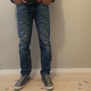 Blå jeansbyxor från Lee Daren - Säljer ett par klassiska blå jeans från Lee, modell Daren. Byxorna har normal passform och raka ben, med fem fickor och Lee-logga på bakfickan. Perfekta till vardags och lätta att matcha med olika stilar. 30/32