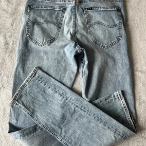 Ljusblå Lee Daren Zip Fly ljusblå jeans 29/34 - Säljer ett par klassiska ljusblå jeans från Lee, modell Daren Zip Fly. Jeansen har raka ben, normal passform och femficksdesign med dragkedjegylf. Perfekta för dig som gillar en tidlös denimlook.