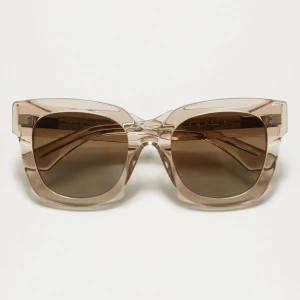 Beige transparenta solglasögon från Chimi - Stilrena solglasögon från Chimi i en transparent beige färg med fyrkantig form. Bågarna är tillverkade i plast och har bruna tonade glas. Perfekta för att lyfta din look med en modern touch. Helt oanvända bara provade! 