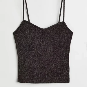 Svart glittrigt linne - Svart glittrigt linne med smala axelband och lätt v-ringad halsringning. Endast använd 1 gång, så mycket bra skick.