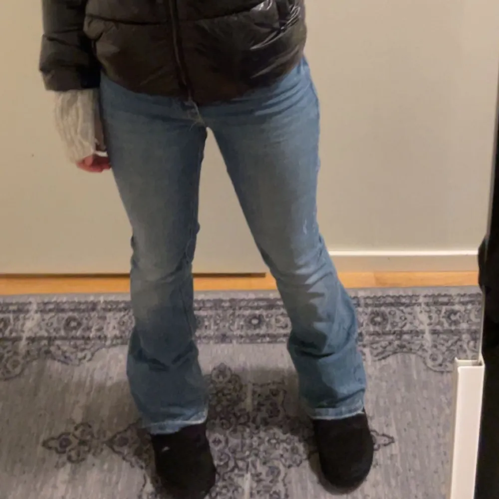 Säljer ett par klassiska blå bootcut jeans med normal passform. Jeansen har en medel midja och är tillverkade i denim. Perfekta för dig som gillar en tidlös stil med lite utsvängda ben.. Farkut & Housut.