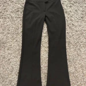 Svarta bootcut kostymbyxor från Gina Tricot - Säljer ett par svarta kostymbyxor från Gina Tricot med bootcut-passform. Byxorna har låg midja, stängs med hake och dragkedja och är tillverkade i ett mjukt, stretchigt material. Använda 1 gång. Skriv om ni har frågor😊