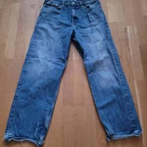 Blå galaxy straight loose jeans från Weekday - Säljer ett par blå jeans från Weekday i loose, baggy modell. Jeansen har raka ben, fransade benslut och klassisk femficksdesign. Perfekta för dig som gillar en avslappnad stil. Bra begagnat skick, dock är fållen vid besluten fransig, se bilderna. 