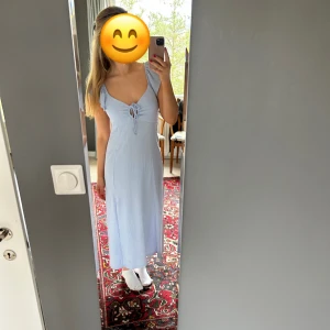 Ljusblå långklänning med knyt fram - Säljer en ljusblå långklänning med v-ringning och knyt fram. 