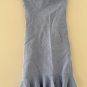 Ljusblå axelbandslös klänning med volang - Säljer en ljusblå axelbandslös klänning med volang nertill. Klänningen har en tight passform och är perfekt för dig som vill ha en enkel men stilren look. Materialet känns mjukt och följsamt.