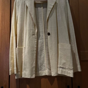 Gul kavaj från Gina Tricot💛 - Stilren butteryellow kavaj från Gina Tricot med en knapp framtill och stora fickor. Kavajen har lång ärm och är tillverkad i ett linneliknande material som ger en avslappnad men ändå dressad känsla.💛