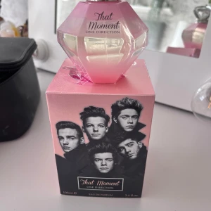 That Moment Eau de Parfum från One Direction - Säljer en parfym 'That Moment' från One Direction. Flaskan är diamantformad i rosa glas med silverdetaljer och kommer i en rosa kartong med bandets bild på framsidan. Innehåller 100ml och har använt den endast fåtal gånger. Som ny