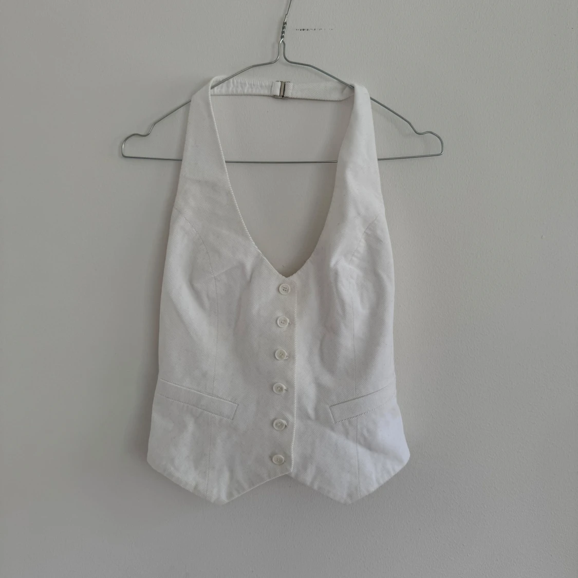 Vit väst med djup v-ringning från mango