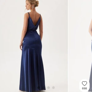 Marinblå balklänning - Marinblå balklänning med lösare v-ringning fram och baktill, helt ny med prislapp, "vikningar" i midjan (sista bilden), justerbara band, slutslåd på hemsidan orginalpris är 999kr