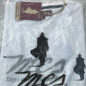 Vit t-shirt med svart tryck - Vit t-shirt från MCS med coolt svart tryck av en siluett i hatt och rock. Perfekt för dig som gillar stilrena och unika motiv. Rund halsringning och klassisk passform.