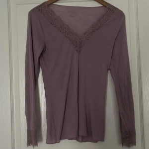 Ljuslila långärmad topp med spets från Intimissimi - Säljer en ljuslila långärmad topp från Intimissimi med v-ringning och fina spetsdetaljer. Använd en gång och som helt ny inga hål och funkar som S❣️