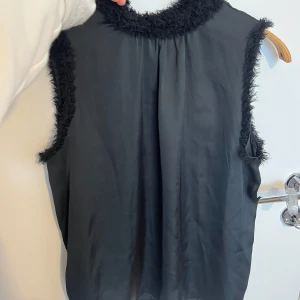 Svart top med fransar - Snygg svart ärmlös topp med hög krage och fluffiga detaljer.🫶