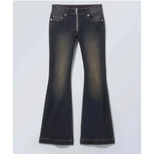 Svarta bootcut jeans med dragkedja - Snygga svarta bootcut jeans med dragkedja framtill och klassiska fickor. Jeansen har en lätt urtvättad look och vida ben nertill för en trendig siluett.