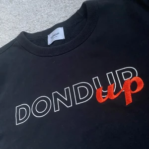 Dondup Tröja - Säljer en svart tröja från Dondup. Den är stilren och passar till det mesta. Tröjan är gjord i mjuk bomull och sitter bra på kroppen. Den har en  logga över bröstet och ser lyxig ut utan att sticka ut för mycket.  Storlek: M Skick: Använd fåtal gånger och är i bra skick Nypris: Ungefär 2500kr Pris: 529kr