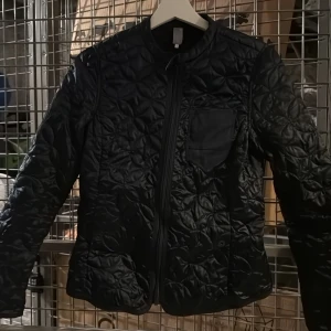 Svart quiltad jacka från G-star  - Säljer en svart quiltad vårjacka från G-star med dragkedja framtill och rund halsringning. Jackan har en bröstficka och två sidofickor. Perfekt för lager-på-lager under kyliga dagar.