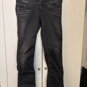 Svarta jeansbyxor med raka ben - Säljer ett par svarta jeansbyxor med klassisk femficksdesign och raka ben. Byxorna har detaljerade sömmar och knappgylf. Passar perfekt till dig som gillar en stilren look.