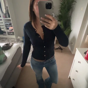 Mörkblå kofta med knappar - Säljer en mörkblå kofta med långa ärmar och knappar framtill. Perfekt att ha öppen eller stängd över ett linne eller t-shirt. Enkel och stilren design som passar till mycket.