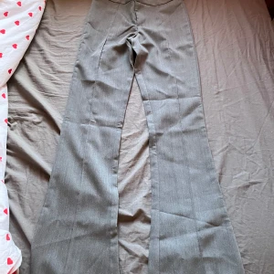 Grå kostymbyxor från HM - Snygga grå kostymbyxor me stråstreck på benen utan fickor ibak. Helt nya oanvända 