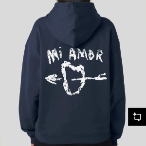 Mörkblå hoodie med tryck från Mira Paris - Säljer en mörkblå hoodie från Mira Paris med vit text 'Mi Amor' och ett hjärta med pil på ryggen. Hoodien har huva, dragsko och magficka. Den är i väldigt bra skick och säljer då den inte kommer till användning! Orginalpris är 1700 men säljer för 1200kr billigare alltså 500kr!!!