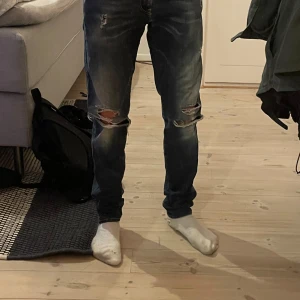Blå slitna jeans från Replay - Säljer ett par blå jeans från Replay, modell Anbass. Byxorna sjysta slitningar och hål på knäna, klassisk femficksdesign och normal passform. Perfekta för en avslappnad och trendig look, pris går att diskuteras vid snabb affär🤩