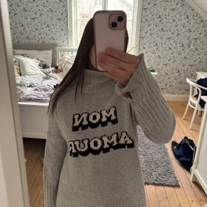 Grå stickad polotröja från Zadig & Voltaire - Säljer en grå stickad polotröja från Zadig & Voltaire med texten 'Mon Amour' i svart och vitt framtill. Tröjan har lång ärm, ribbade muddar och en oversized passform. Perfekt för kyliga dagar och riktigt snygg till jeans. Använd ytterst få gånger💓💖🌟