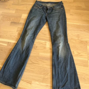 Blå bootcut jeans - Säljer ett par blå bootcut jeans från weekday med låg midja ( Modell Nova low slim bootcut ). De är lite slitna där nere men annars i bra skick 