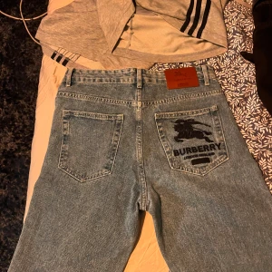 Burberry x Supreme jeans - Säljer ett par ljusblå jeans från Burberry i samarbete med Supreme. Byxorna har klassisk femficksdesign, Burberry-logga och ryttare broderad på bakfickan samt Supreme-tag. Skinnpatch med Burberry-märke i midjan.