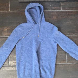 Merinoulls hoodie - Säljer denna merinoulls hoodie i en unik snygg blå färg. Riktigt skön och fint skick, passar mig helt perfekt som är 171, men passar allt från 163-173 Ca. Vid frågor eller funderingar skriv gärna.