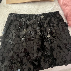Nelly glitter kjol i svart - Kjol i svart glitter, fin, storlek M