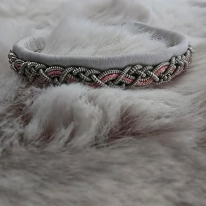 Handgjort samiskt armband i vitt skinn med tenntråd och rosa detaljer - Unikt armband i vitt skinn med flätad tenntråd och inslag av rosa. Armbandet har ett snyggt mönster och stängs med en dekorativ knapp. Perfekt accessoar för dig som gillar traditionell design med modern touch. För handledsmått 16-18cm