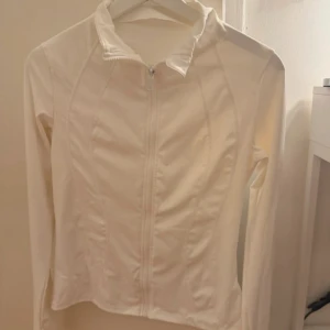 Träningskofta - Säljer en vit, träningskofta med dragkedja framtill och lång ärm. förstor för mig! inga deflekter 